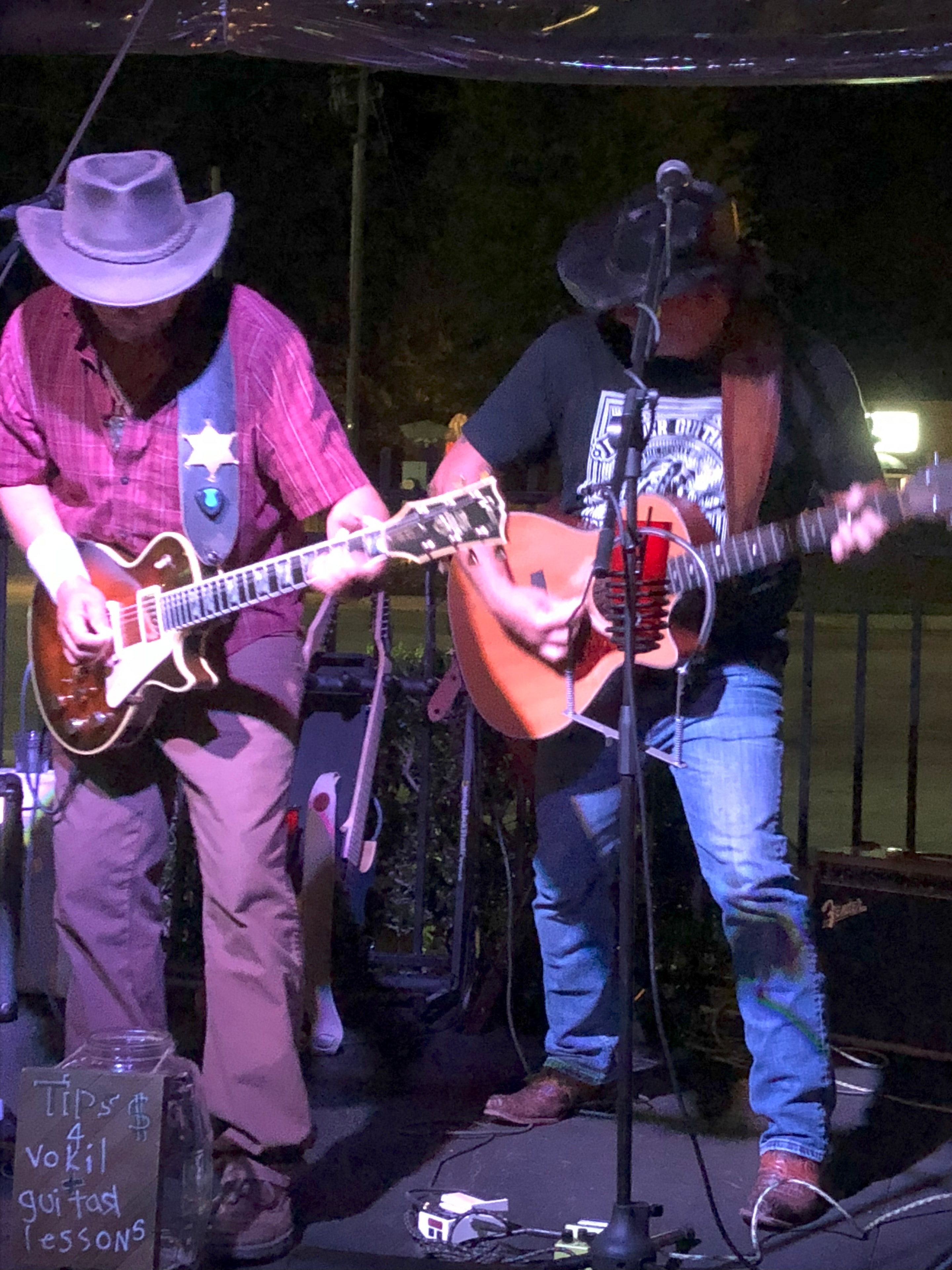 Marc Kenney and Jimmy Waters performing live outdoors with guitars