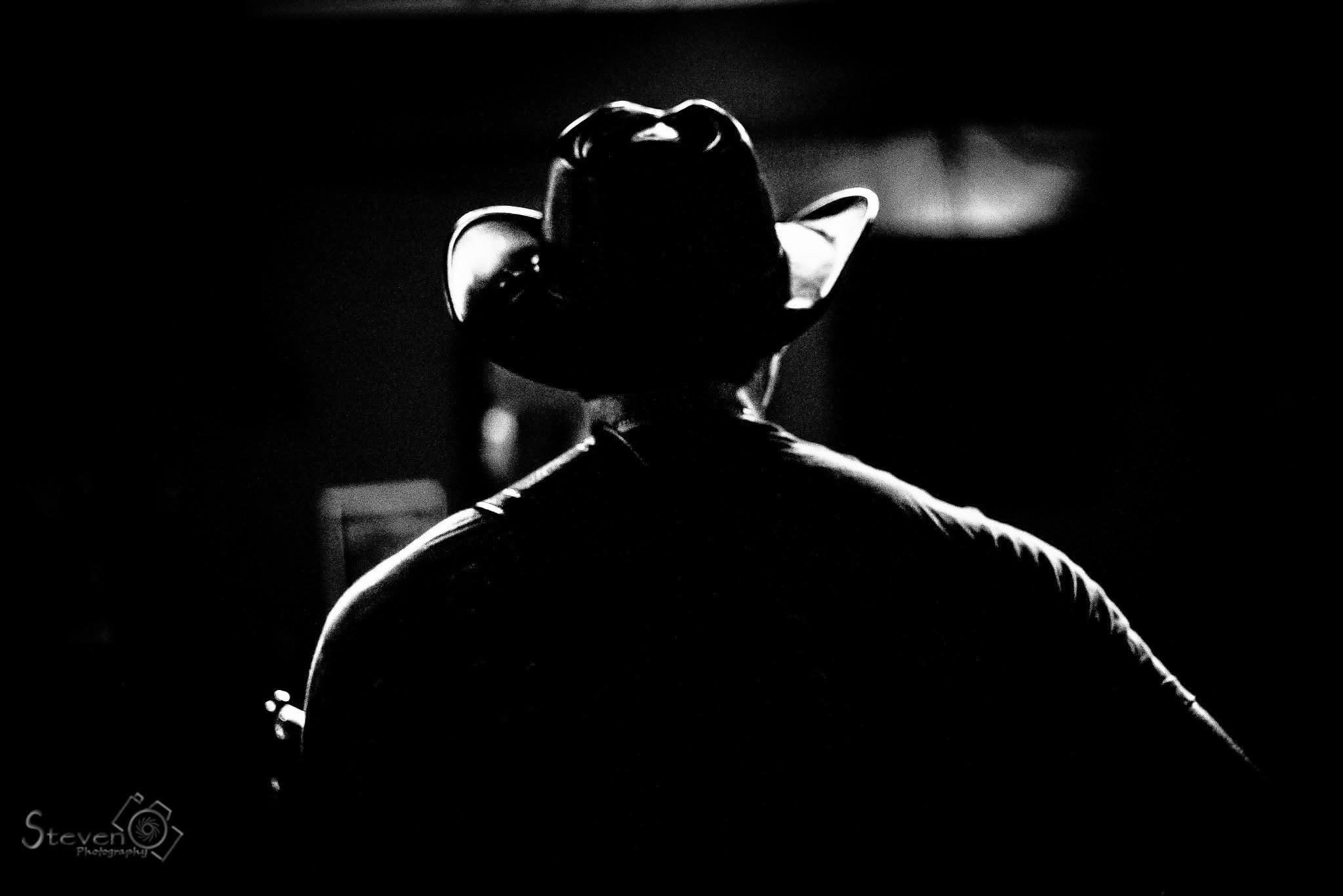 Guitarist performing with acoustic guitar under dramatic stage lighting