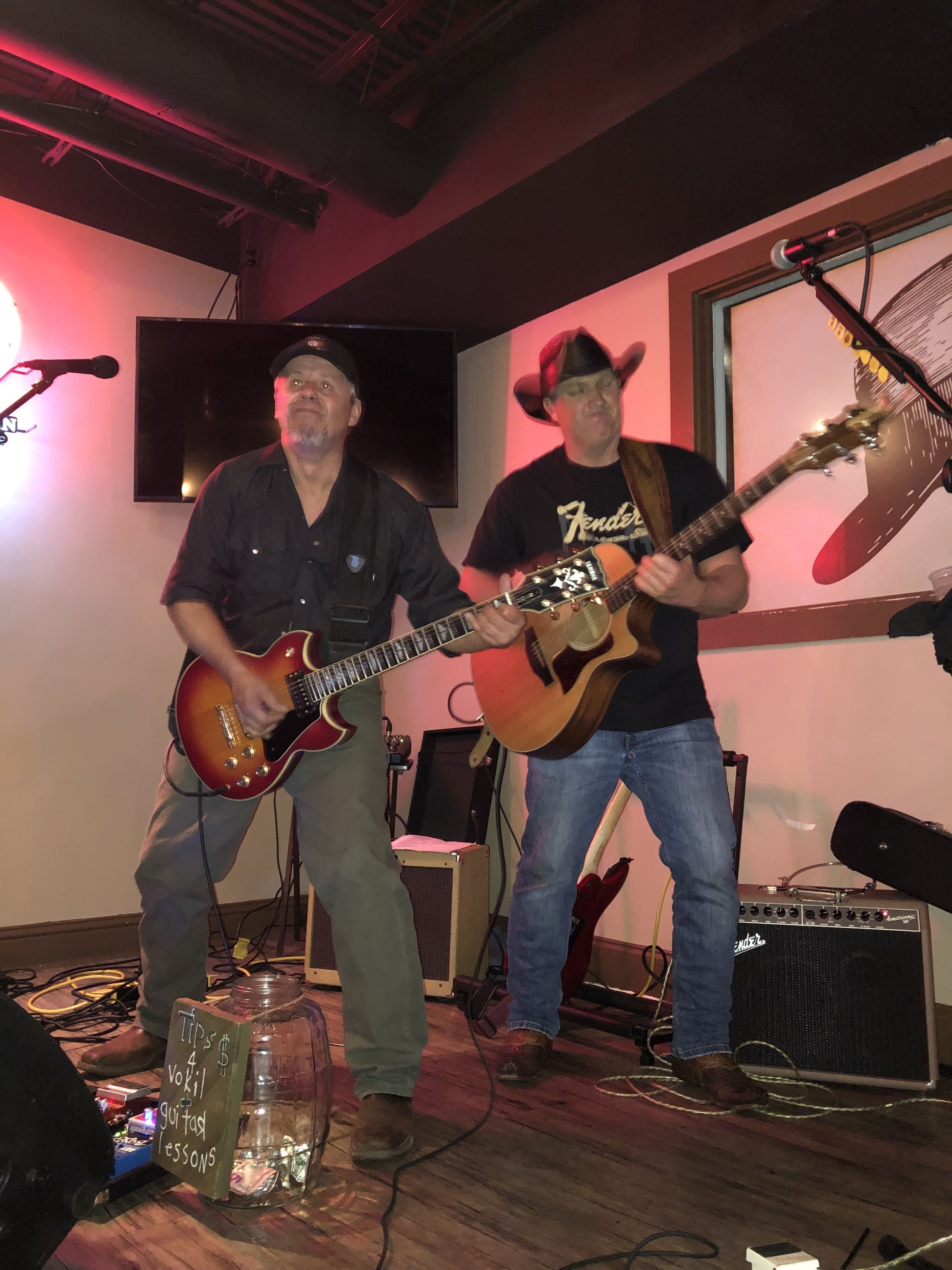Marc Kenney and Jimmy Waters performing live with pink/red ambient lighting