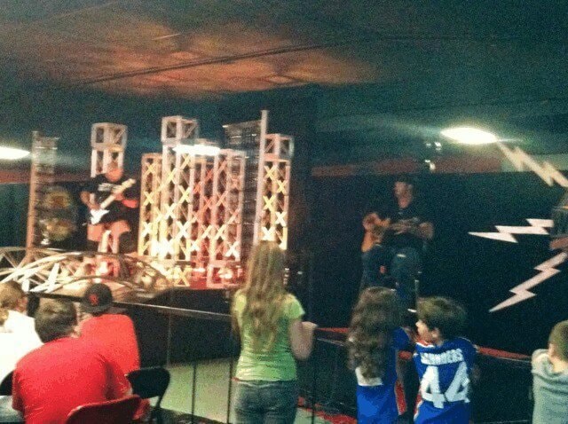 Marc Kenney Band performing on stage with metal trusses and crowd in front