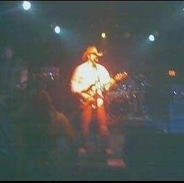 Marc Kenney performing live on stage with warm concert lighting