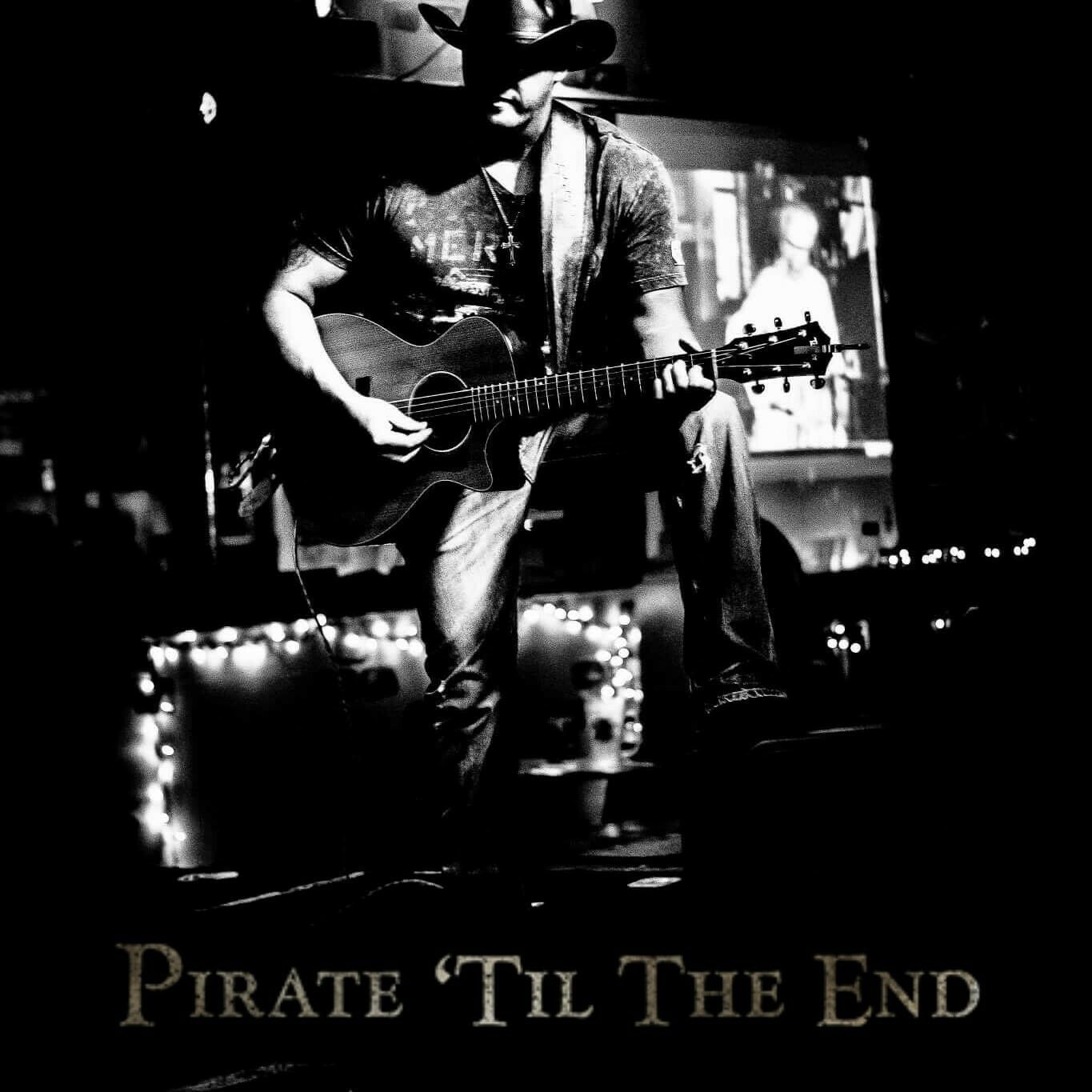 Marc Kenney performing acoustic guitar on stage — "Pirate 'Til The End"
