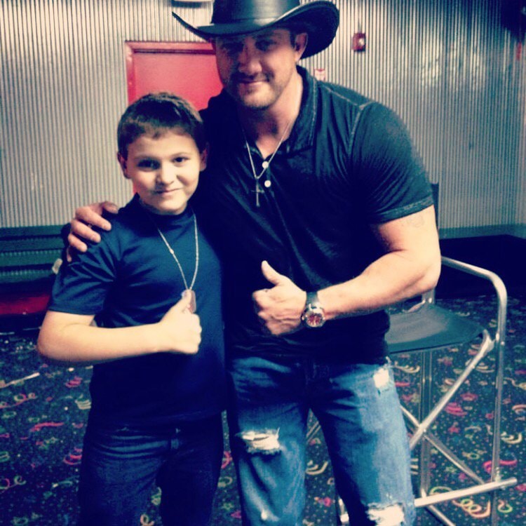 Marc Kenney posing with a young fan, both giving thumbs up